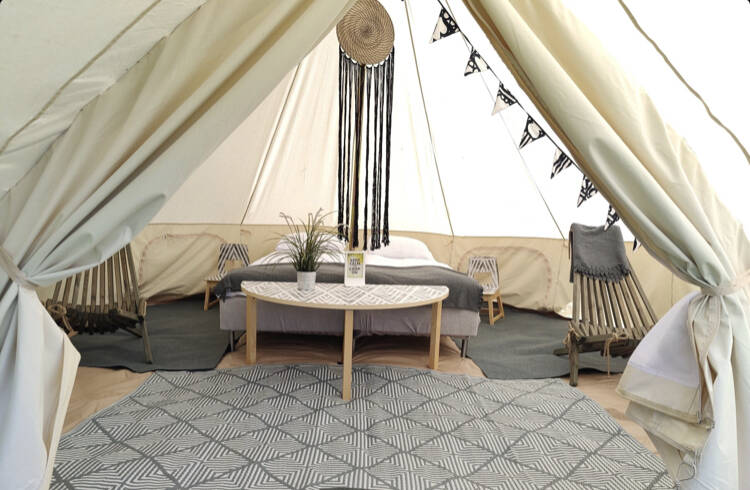 Glamping-teltan mallikuva. Kuvassa kahdelle hengelle sisustettu teltta jossa kaksi sänkyä ja muita kalusteita.