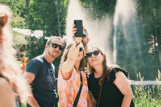 Festivaalivieraat ottavat porukalla selfie-kuvaa suihkulähteen edessä.