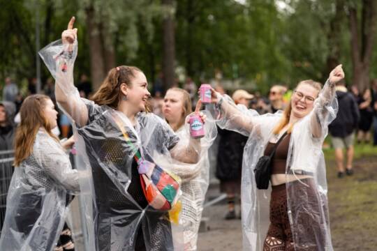 Sateessa tanssivia onnellisia ihmisiä
