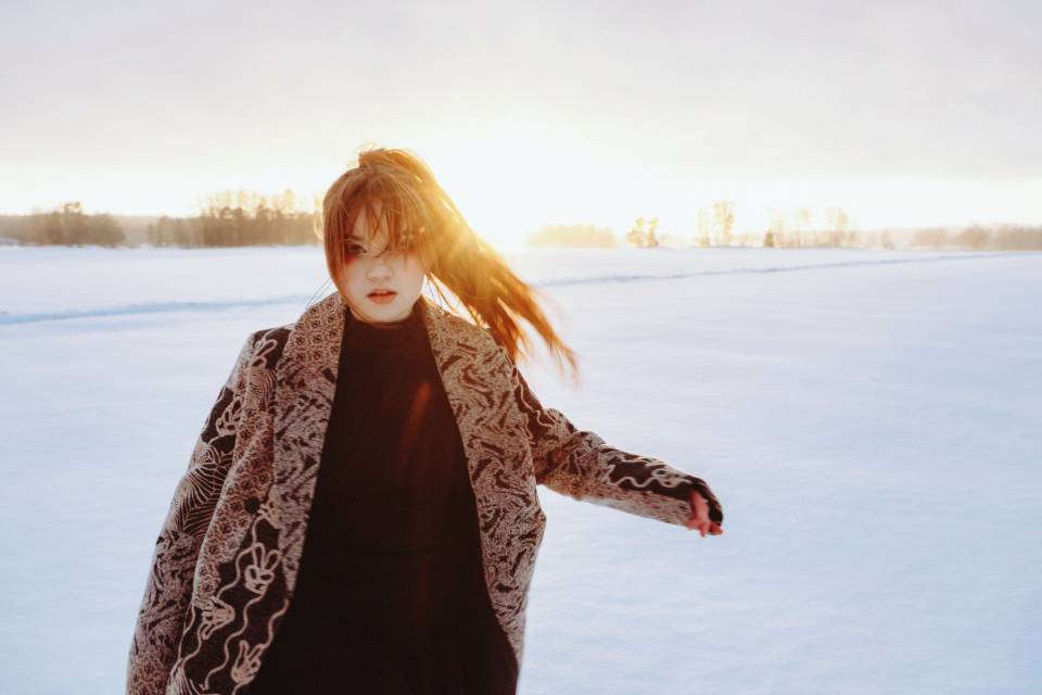 Saga Mast, artisti ja lunta ja auringonlasku taustalla.