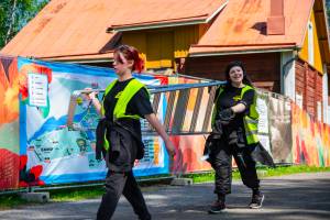 Vapaaehtoiset kantamassa tikkaita alueella rakennuksen aikana.