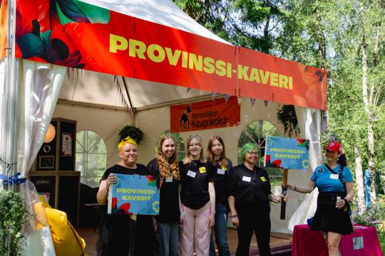 Provinssikaveri-vapaaehtoiset katsovat iloisesti kameraan Provinssikaveri-teltalla.