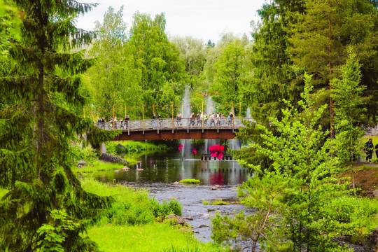 Vehreää Provinssialuetta ja asiakkaita kävelemässä sillalla.